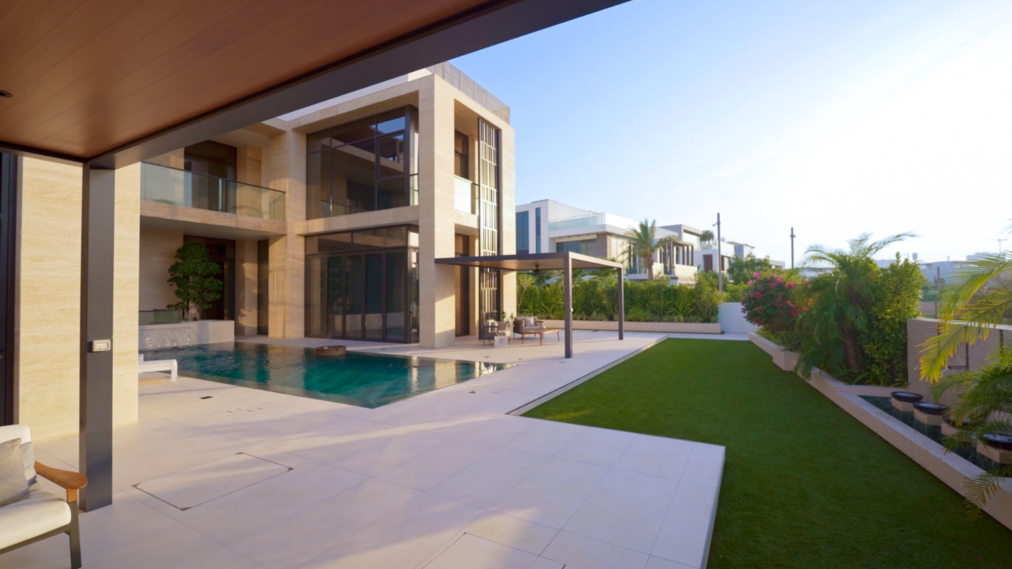 Villa landscaping at Emerald, Dubai Hills with a swimming pool, lawn and shaded pergola terrace