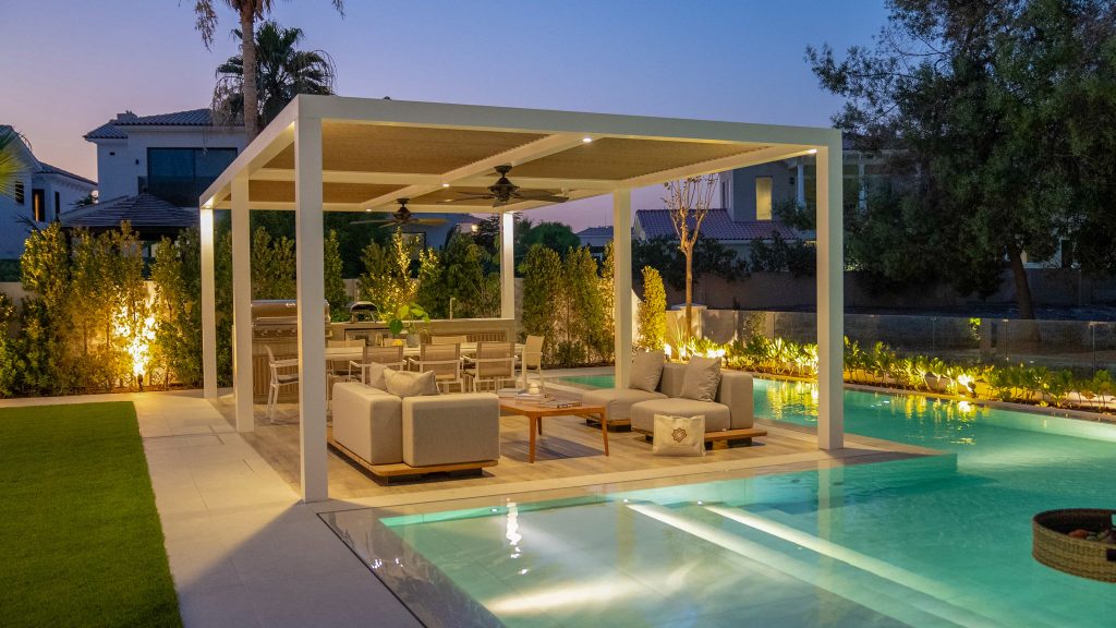 Villa landscape design and build in Dubai with a swimming pool, water spouts, in-water loungers, lawn and shaded pergola lounge