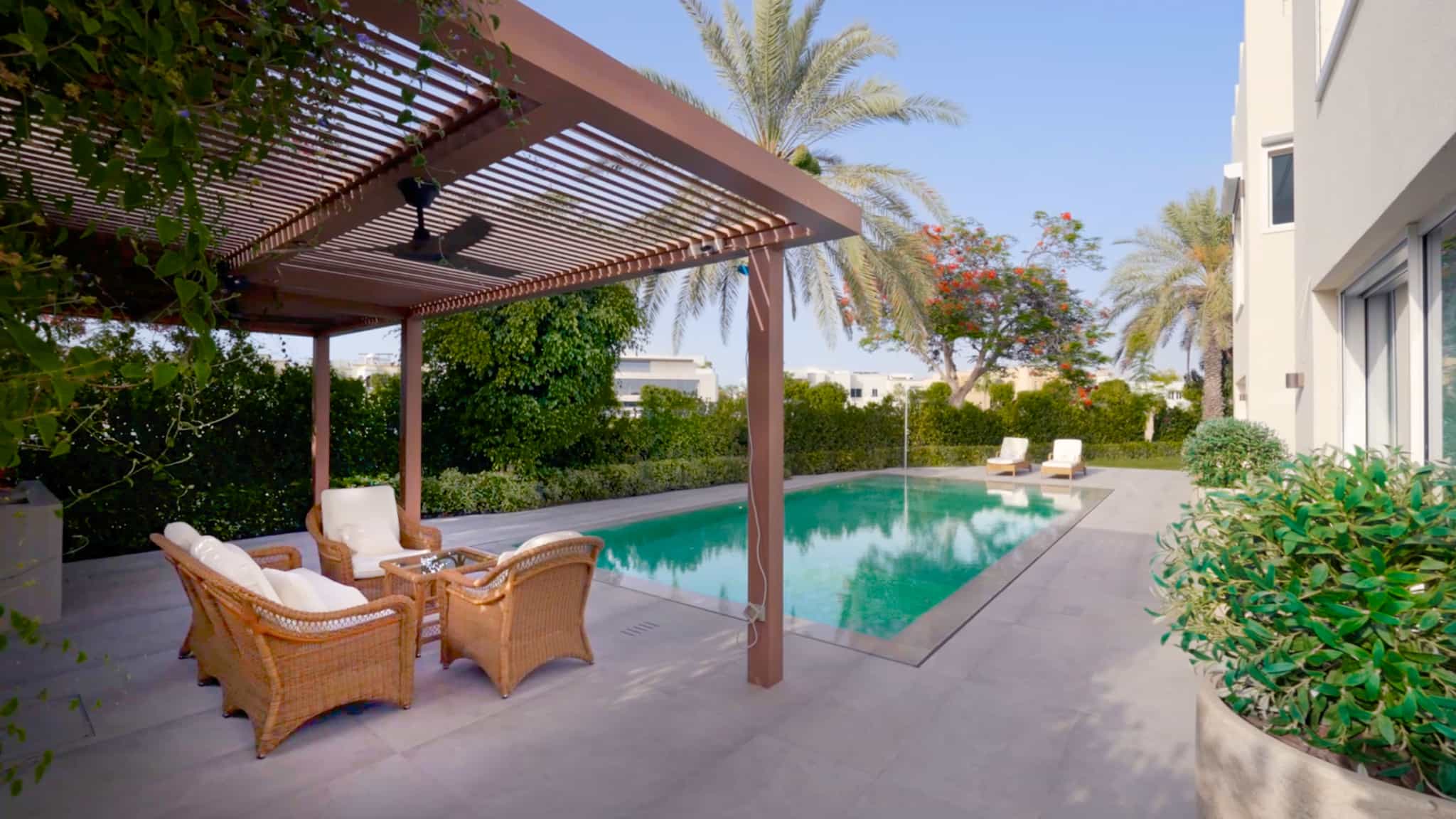Villa landscaping at The Meadows, Dubai with a swimming pool and timber pergola seating area