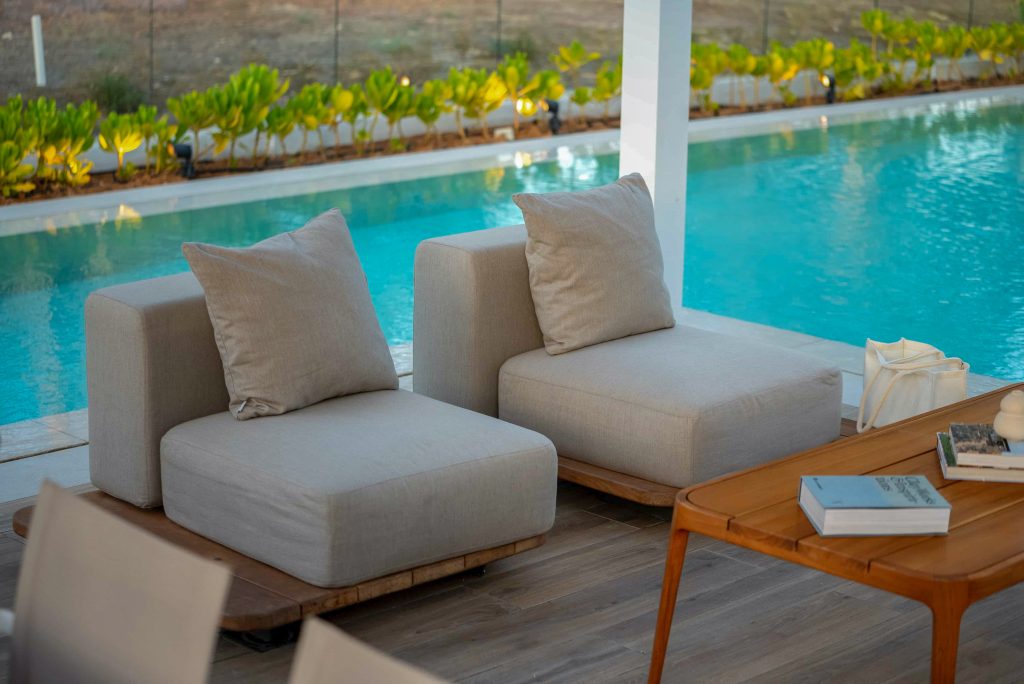Villa landscape design and build in Dubai with a swimming pool, water spouts, in-water loungers, lawn and shaded pergola lounge