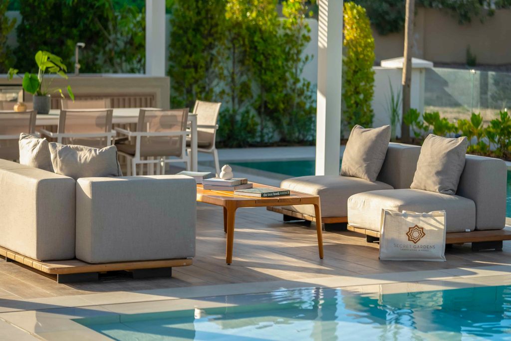 Villa landscape design and build in Dubai with a swimming pool, water spouts, in-water loungers, lawn and shaded pergola lounge