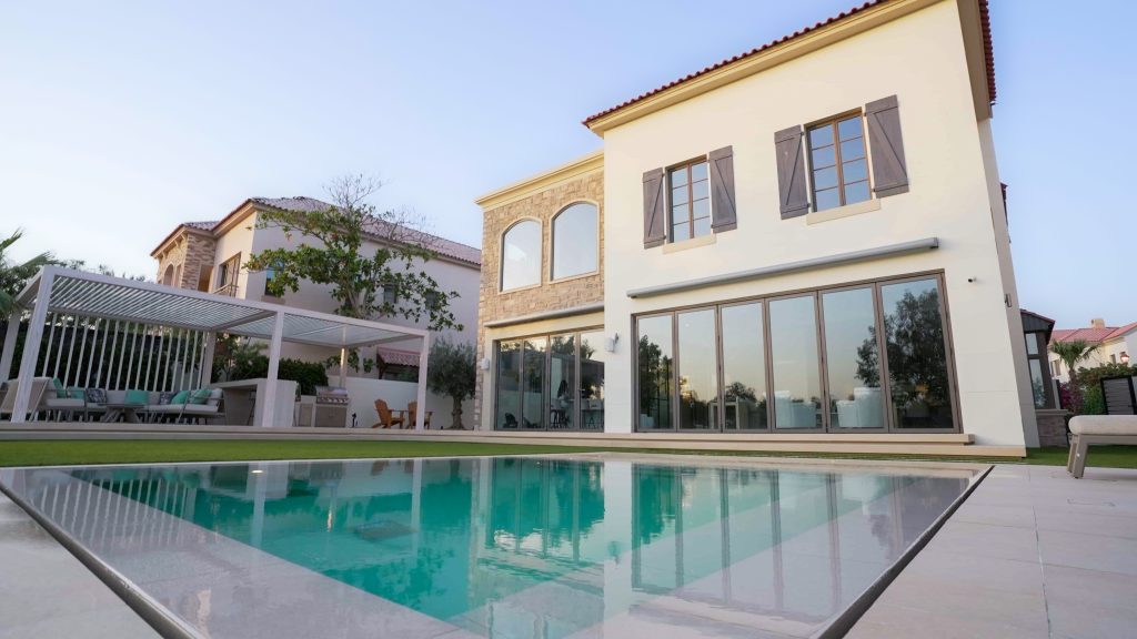Villa landscape design and build in Jumeirah Golf Estates, Dubai with a swimming pool, poolside lounge seating, lawn and shaded pergola