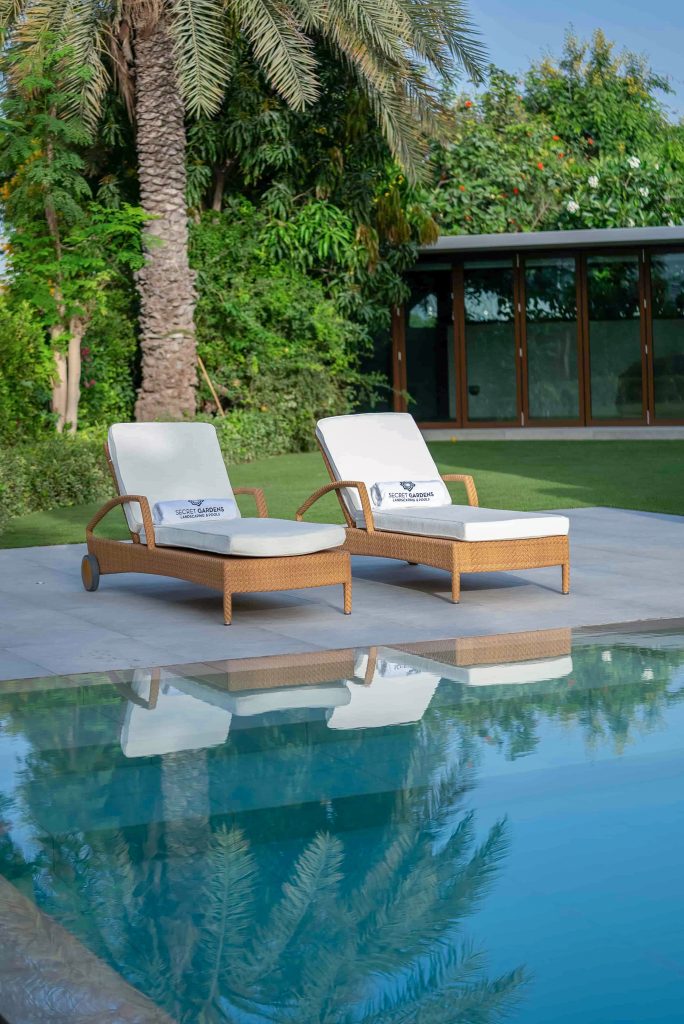 Villa landscape design and build in The Meadows, Dubai with a swimming pool, shaded poolside seating, built-in bench and garden lighting
