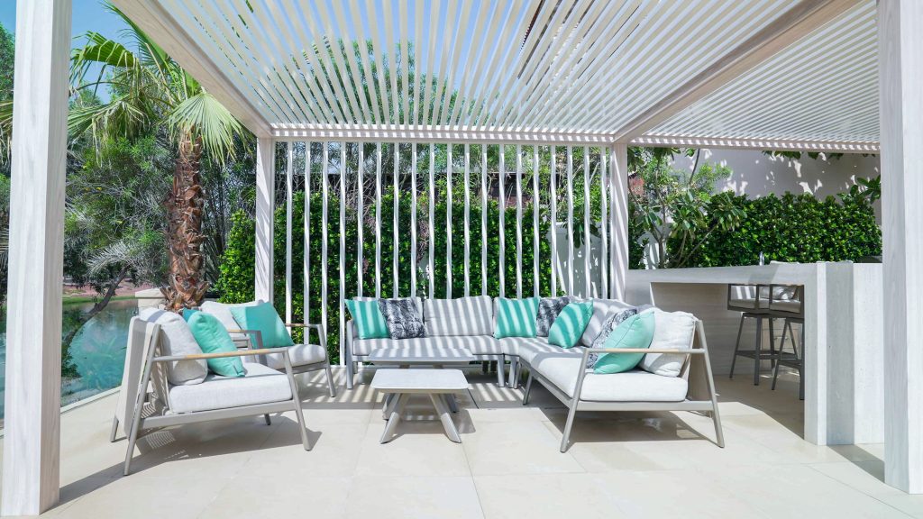 Villa landscape design and build in Jumeirah Golf Estates, Dubai with a swimming pool, poolside lounge seating, lawn and shaded pergola