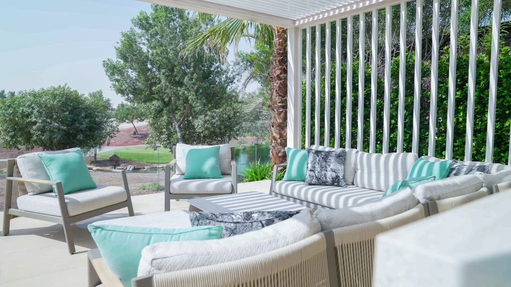 Villa landscape design and build in Jumeirah Golf Estates, Dubai with a swimming pool, poolside lounge seating, lawn and shaded pergola