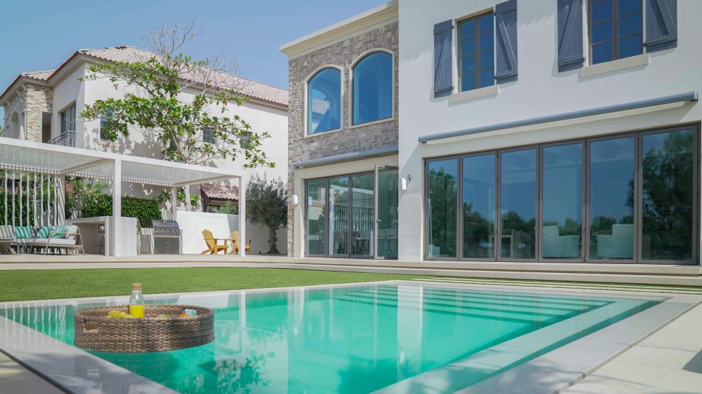 Villa landscape design and build in Jumeirah Golf Estates, Dubai with a swimming pool, poolside lounge seating, lawn and shaded pergola